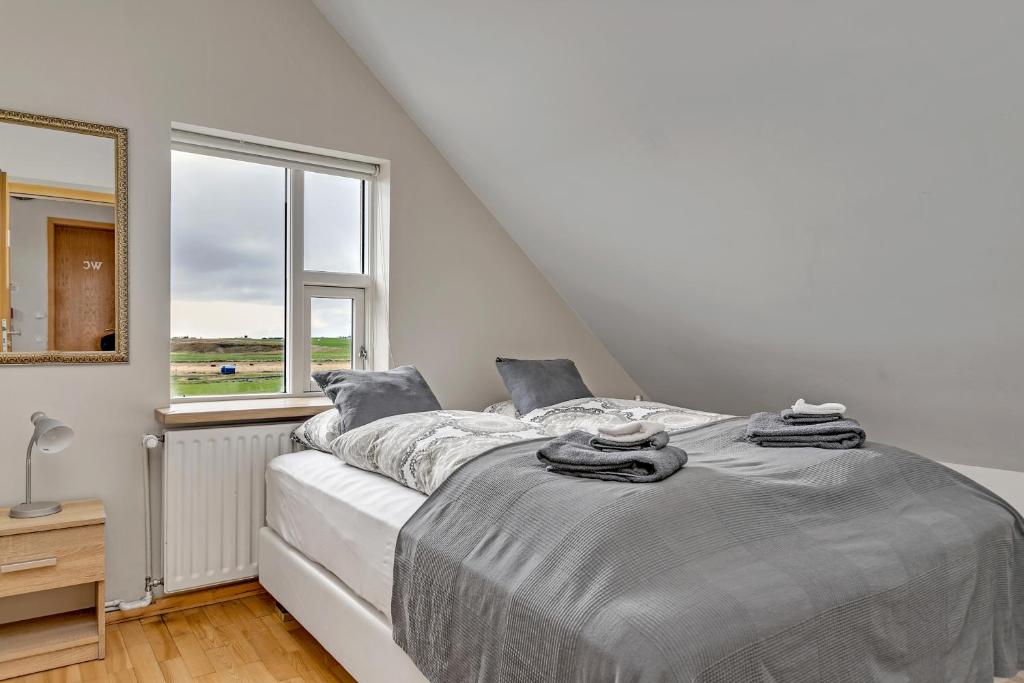 a bedroom with a large bed with a window at Guesthouse Vatnsholt in Vatnsholt