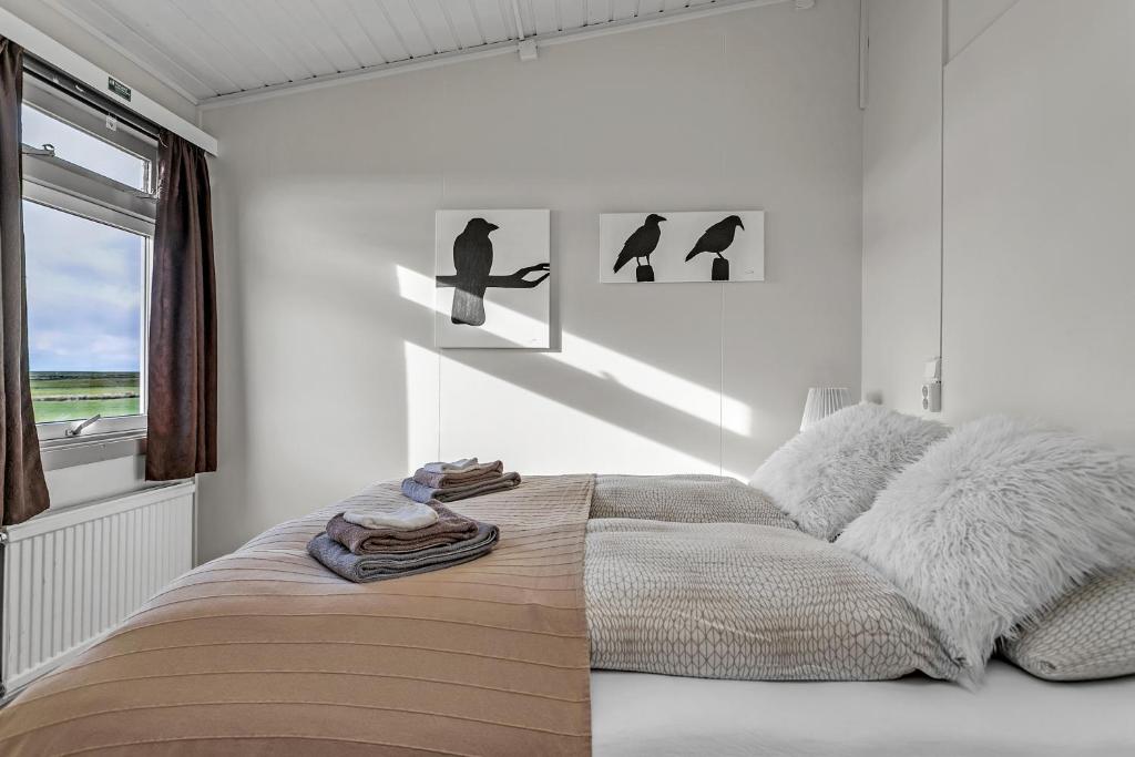 a bedroom with a bed with two birds on the wall at Guesthouse Vatnsholt in Vatnsholt