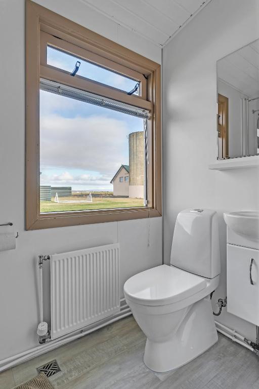 a bathroom with a white toilet and a window at Guesthouse Vatnsholt in Vatnsholt