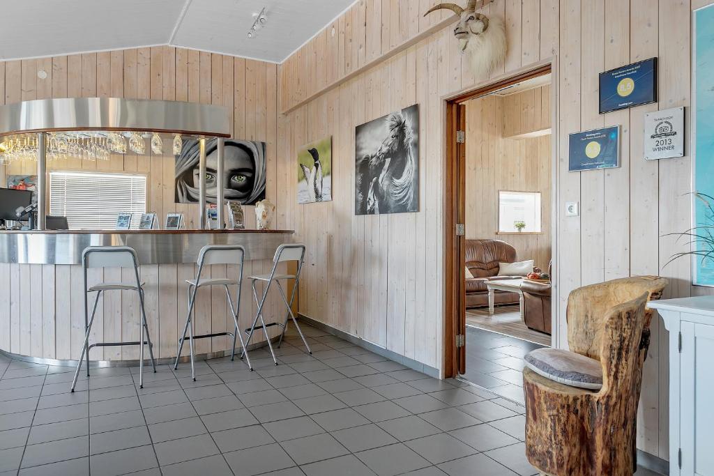 a kitchen with a bar and stools in a room at Guesthouse Vatnsholt in Vatnsholt
