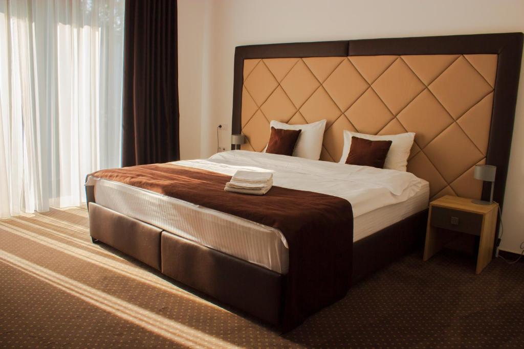 ein Schlafzimmer mit einem großen Bett mit einem großen Kopfteil in der Unterkunft Bernardazzi Grand Hotel in Chişinău
