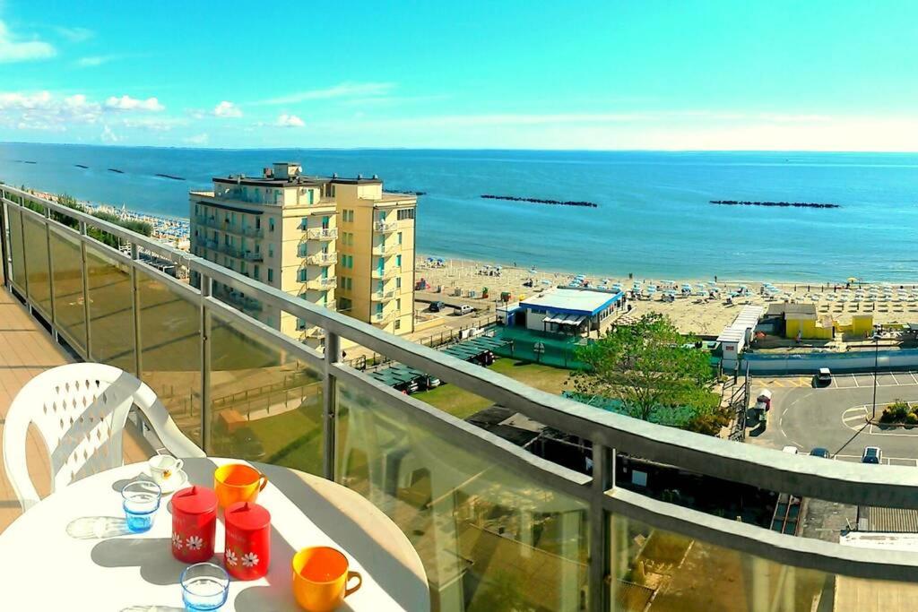 una mesa en un balcón con vistas a la playa en Cortina 1-83, en Lido di Pomposa