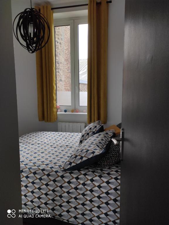 a bedroom with a bed and a window at L' ALBATROS vue sur le port in Fécamp