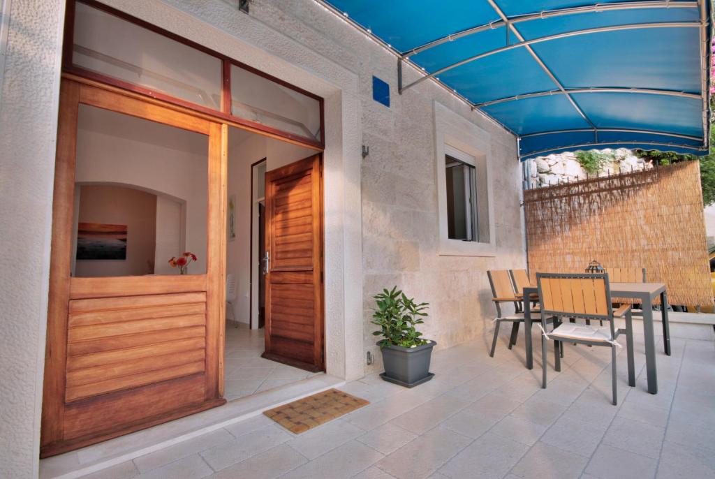 a patio with a wooden door and a table and chairs at Apartment Žara 2 with Boat Place in Mimice