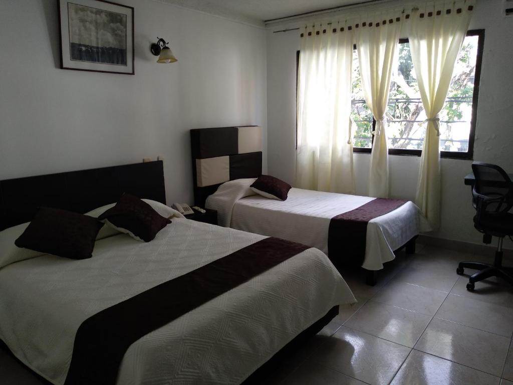 pokój hotelowy z 2 łóżkami i oknem w obiekcie Hotel Nova Park w Arauca