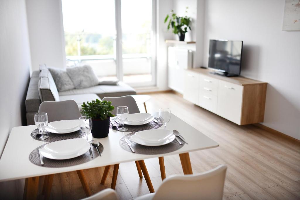un soggiorno con tavolo e sedie bianchi di Apartament Solna C506 a Kołobrzeg