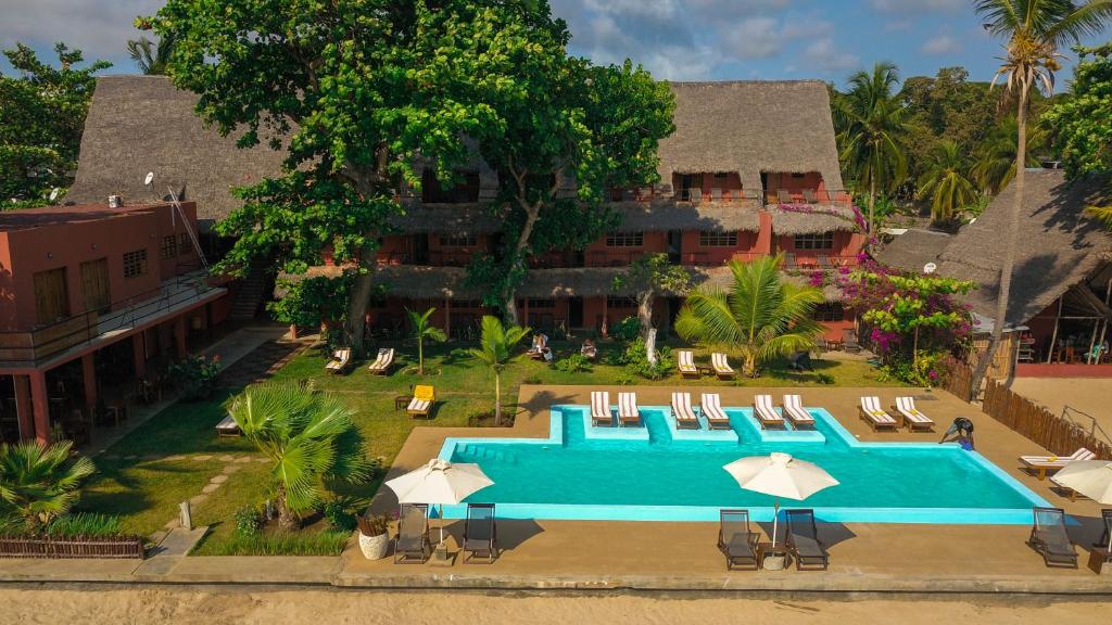 an overhead view of a swimming pool with chairs and umbrellas at Nosy Lodge in Nosy Be