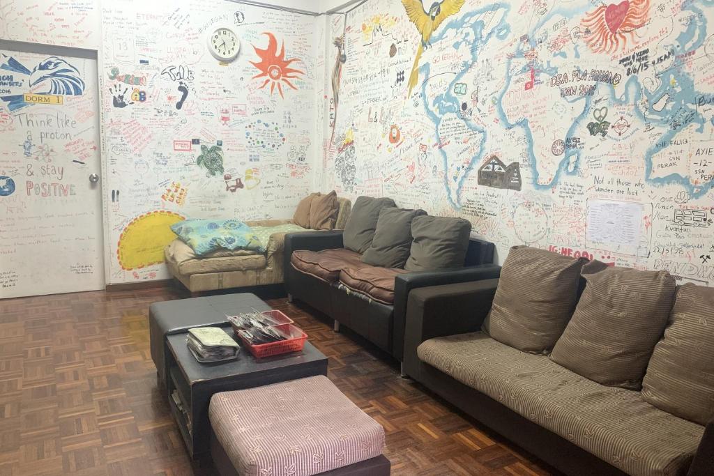 una sala de estar con sofás y un mapa del mundo en SPOT ON 89872 Kuantan Backpackers, en Kuantan