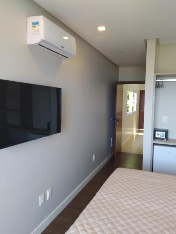 um quarto com uma cama e uma televisão de ecrã plano em Pousada Vila Dos Mares em Morro de São Paulo