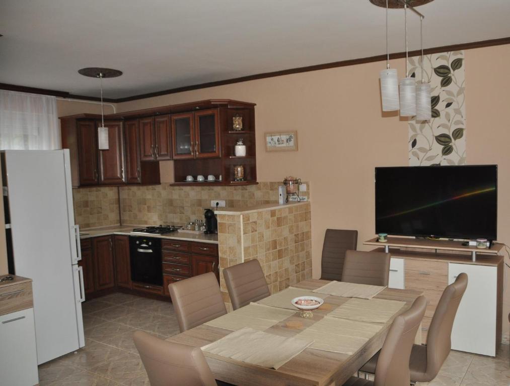 eine Küche und ein Esszimmer mit einem Tisch und einem TV in der Unterkunft Győrszem Apartman in Győr