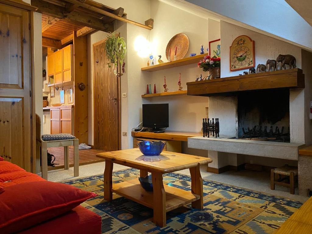 a living room with a fireplace and a table at Appartamento a Gallio con vista sul Sacello in Gallio