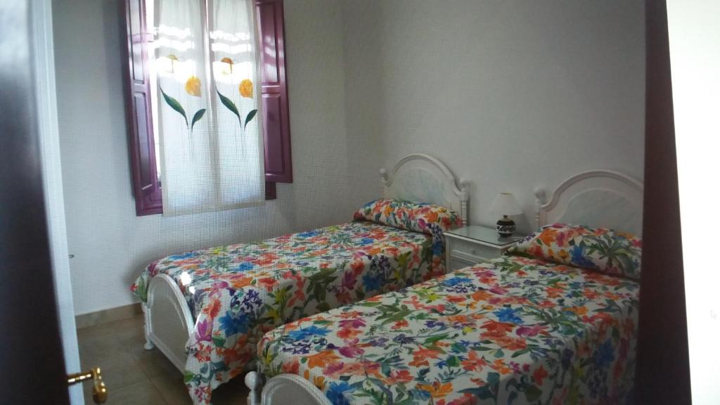 a bedroom with two beds and a window at La Casa Malagueña. in Málaga