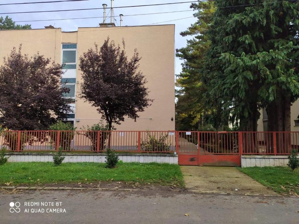 a red gate in front of a building at Erdei Apartman Hajdúszoboszló in Hajdúszoboszló
