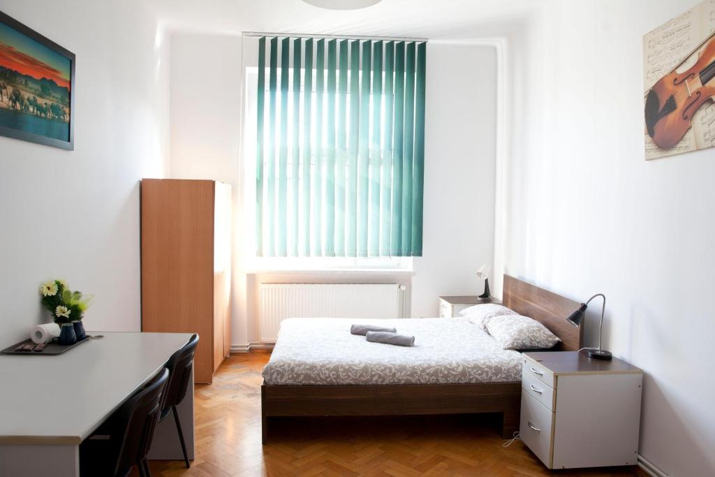 a bedroom with a bed and a desk and a window at Ionia Apartment - Stary Rynek- in Poznań