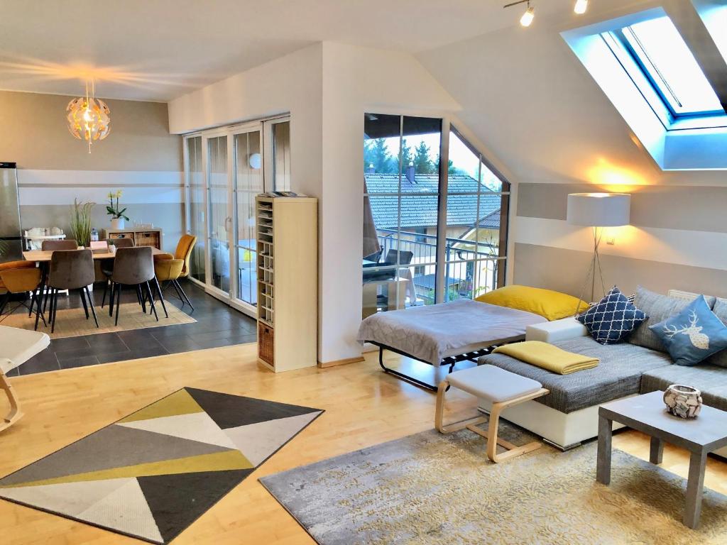 ein Wohnzimmer mit einem Sofa und einem Tisch in der Unterkunft FeWo Atterseeperle - 80m2 mit See- und Gebirgsblick in Steinbach am Attersee