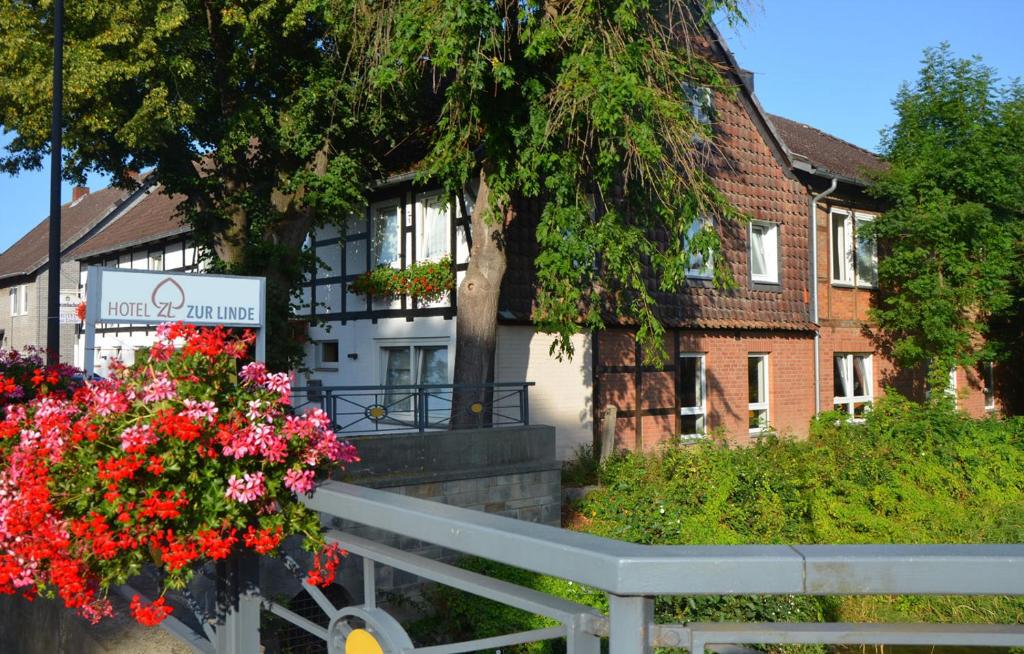 a white bench in front of a building with flowers at Hotel Zur Linde in Salzgitter