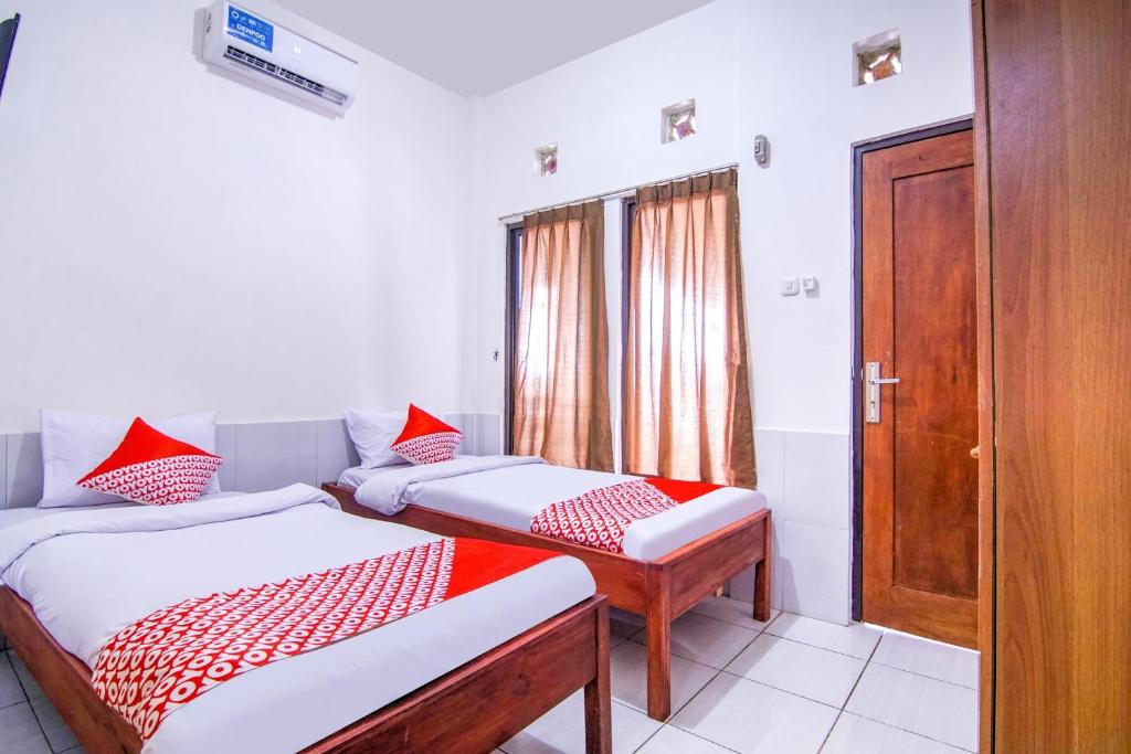 茂物的住宿－OYO 3317 Maju Jaya Homestay Syariah，带门的房间的两张床