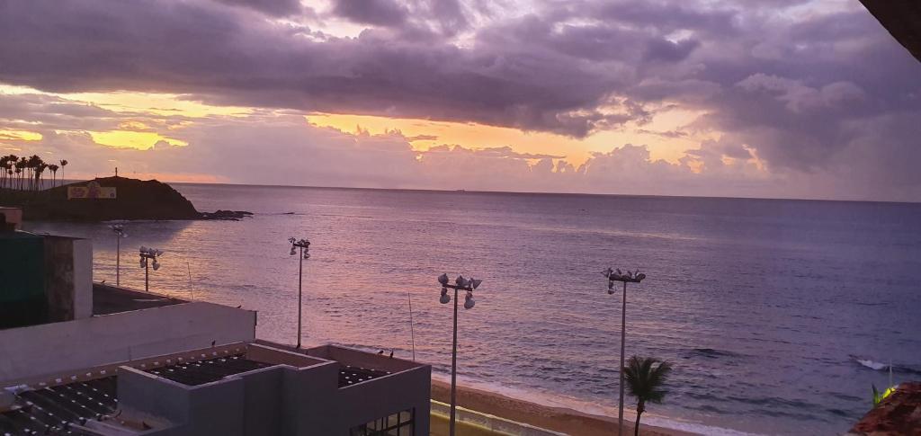 a view of the ocean with a sunset in the background at Farol Barra flat 412 in Salvador