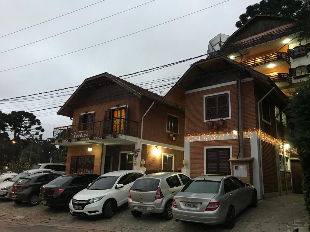 a group of cars parked in front of a house at Pousada da Brigida in Campos do Jordão