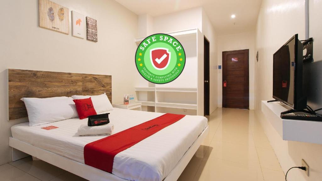 a bedroom with a bed with a sign on the wall at RedDoorz @ Golite Washington in Legazpi