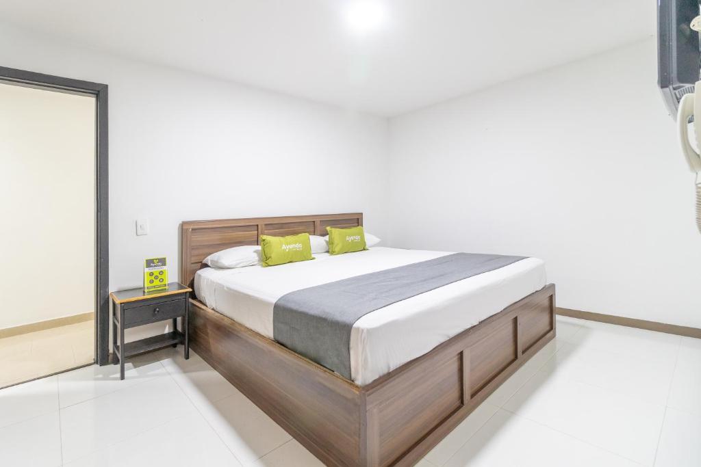 1 dormitorio con 1 cama grande con almohadas amarillas en Hotel Ayenda 1086 Torre 52, en Bogotá