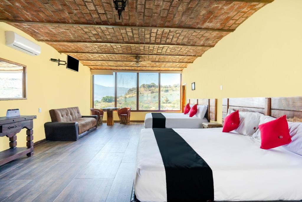a hotel room with two beds and a couch and a desk at Collection O Posada Terraza in Tequila