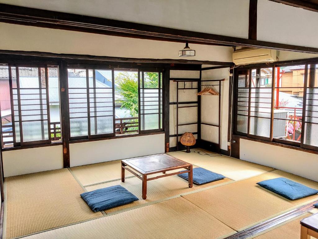 a room with two mats and a table and windows at Guest House Kobako in Kyoto