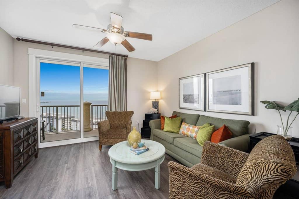 a living room with a couch and a table at Grand Panaama Beach Resort with ocean view in Panama City Beach