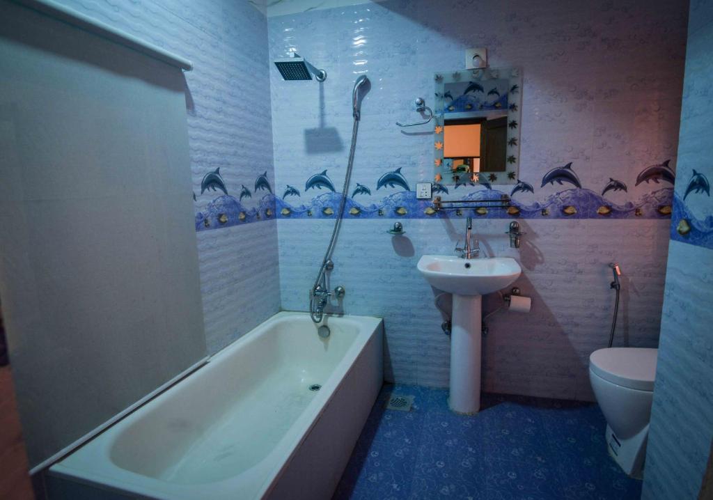 a bathroom with a tub and a sink and a toilet at OYO 789 Hotel Shivam Plaza in Kathmandu