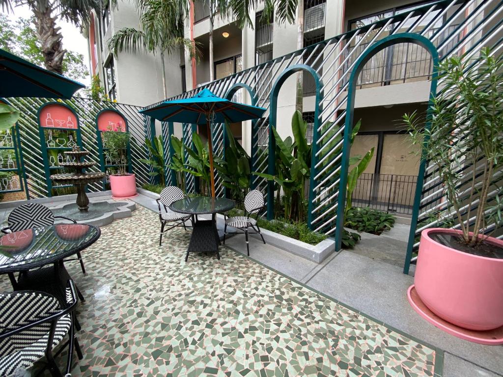 een patio met tafels en stoelen en een parasol bij La habana Huahin in Hua Hin