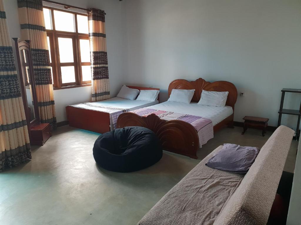 a bedroom with two beds and a couch in it at Trellis Homes in Colombo