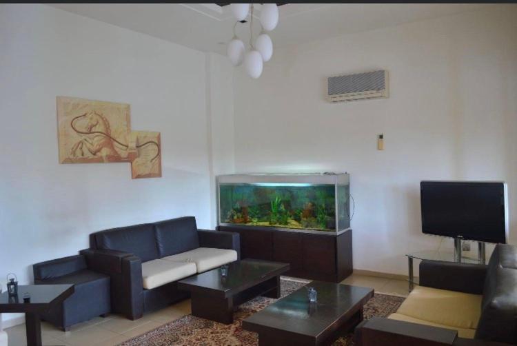 a living room with a couch and a fish tank at Αφροδίτη Hotel in Néon Rýsion