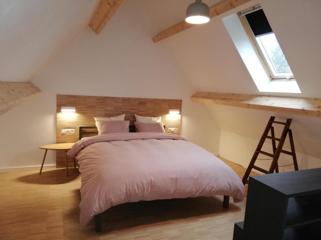 1 dormitorio con cama, escritorio y ventana en Noest, en Destelbergen