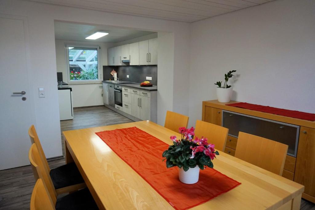 a kitchen with a wooden table with flowers on it at Ferienwohnung Auszeit Zwiefalten in Zwiefalten