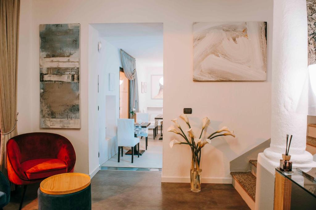 a living room with a red chair and a table at Hotel La Contrada in Verbania