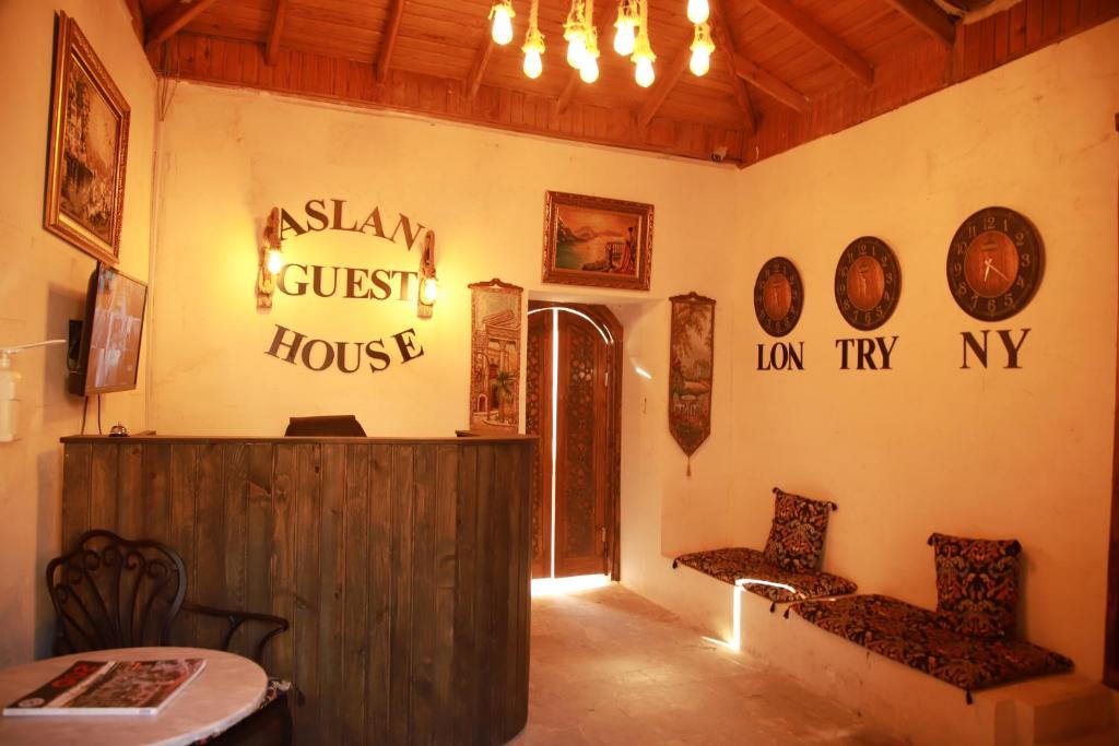 Habitación con 2 sillas, mesa y carteles en la pared en Aslan Guest House, en Sanlıurfa