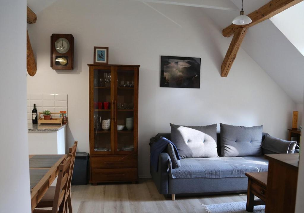 uma sala de estar com um sofá azul e uma cozinha em Apartament Zimorodek Krościenko nad Dunajcem em Krościenko