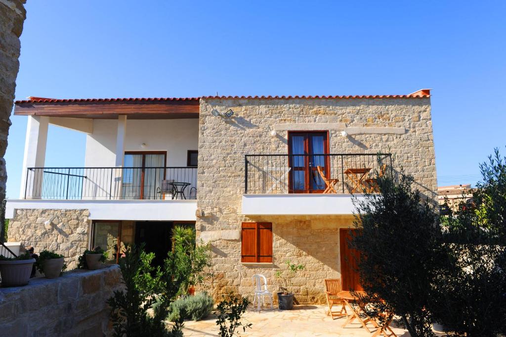 a stone house with red doors and a balcony at Esperando in Maroni