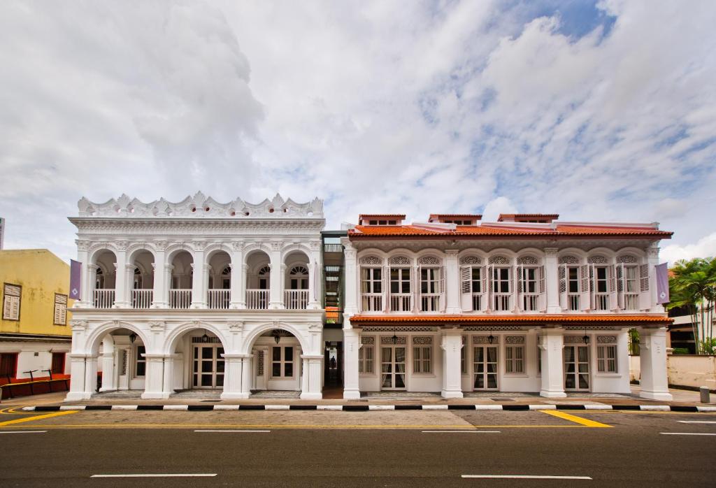 zwei weiße Gebäude am Straßenrand in der Unterkunft The Sultan in Singapur