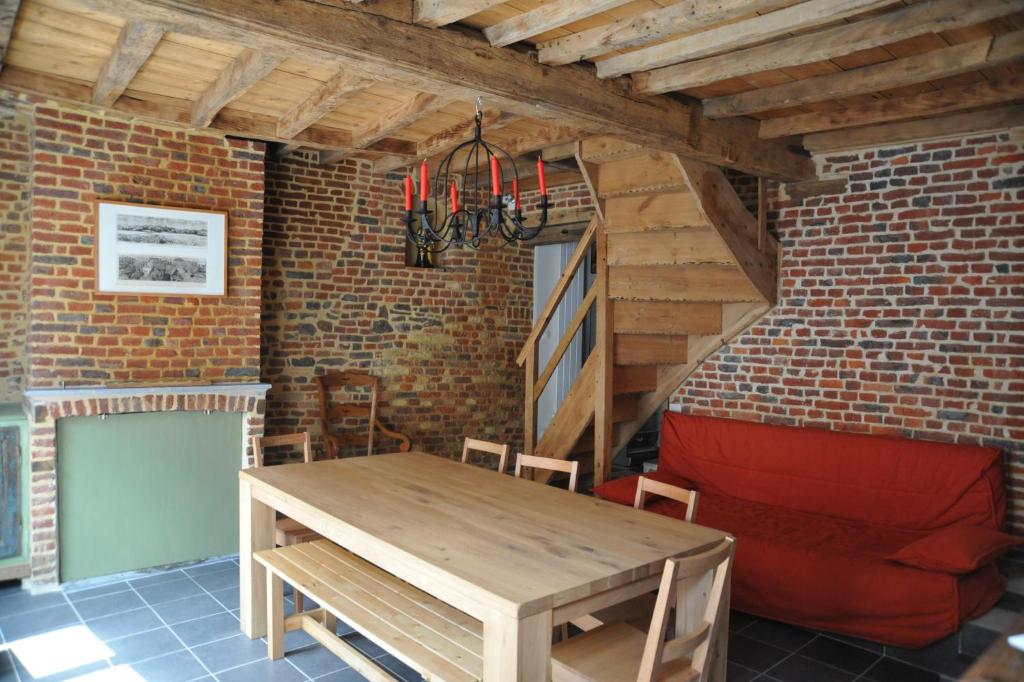 comedor con mesa de madera y pared de ladrillo en Gite de Flandre, en Cassel