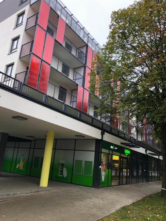 an apartment building with a green and pink facade at Apartament Agnes Szczecin Pomorzany in Szczecin