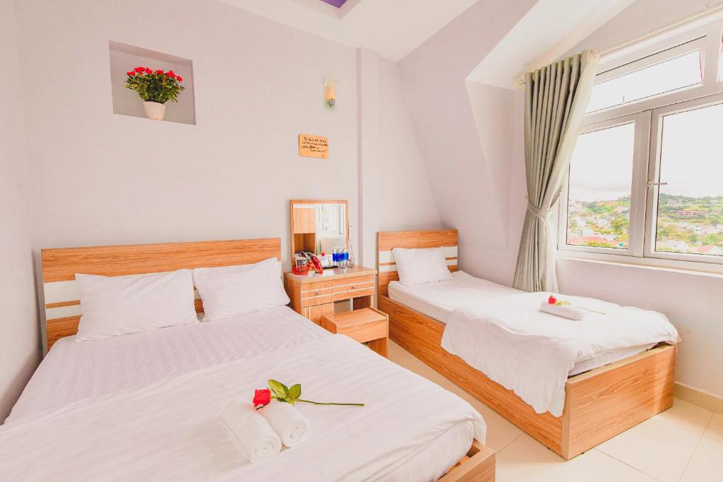 2 camas en una habitación con ventana en Trưởng Sky Hotel Đà Lạt, en Da Lat
