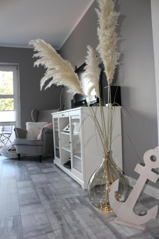 a vase filled with feathers in a living room at Klein Erna (Apth.Holländerei) in Büsum