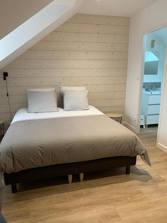 a bedroom with a large bed with white pillows at Côté Source in Pornic