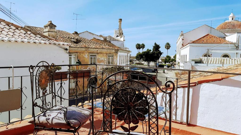 uma varanda com um corrimão de ferro forjado e um edifício em Happy Terrace Downtown Tiny House 100% Portuguese em Faro
