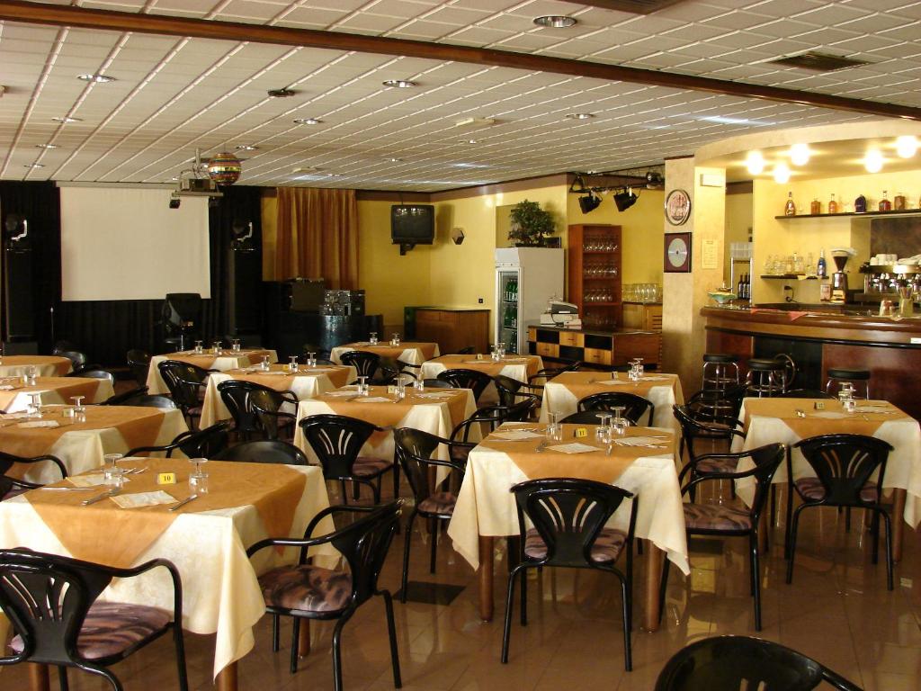 モンティキアーリにあるHotel Faroのテーブルと椅子のあるレストラン、バー