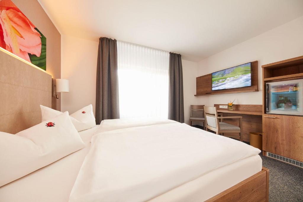 Postel nebo postele na pokoji v ubytování Hotel garni Sonnenhof