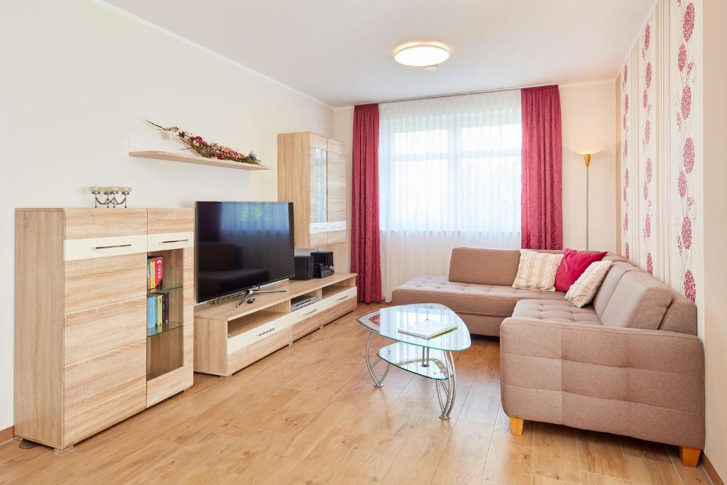 a living room with a couch and a tv at Ferienwohnung im Sonnenhof in Reichenberg
