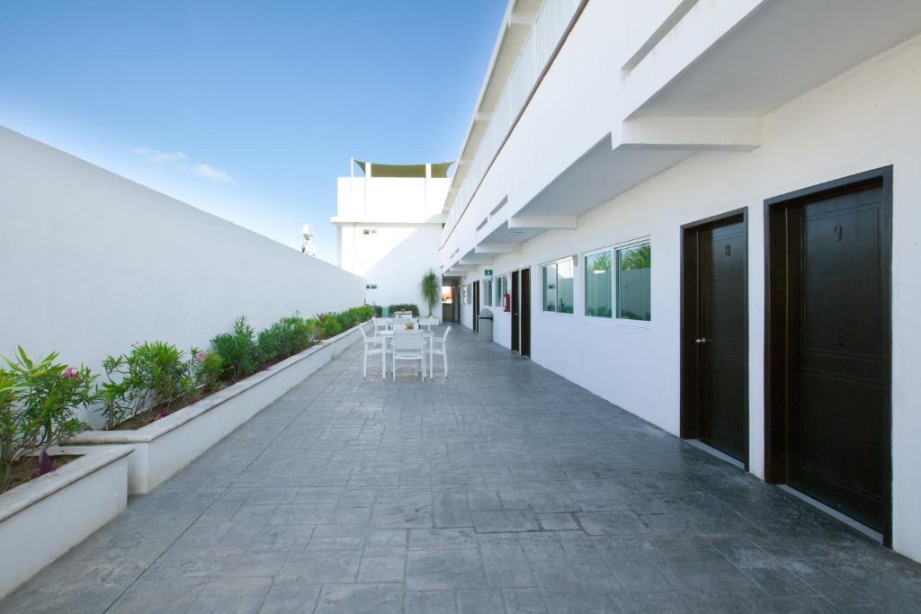 a hallway of a white building with tables and chairs at Hotel Del Sol in Cancún