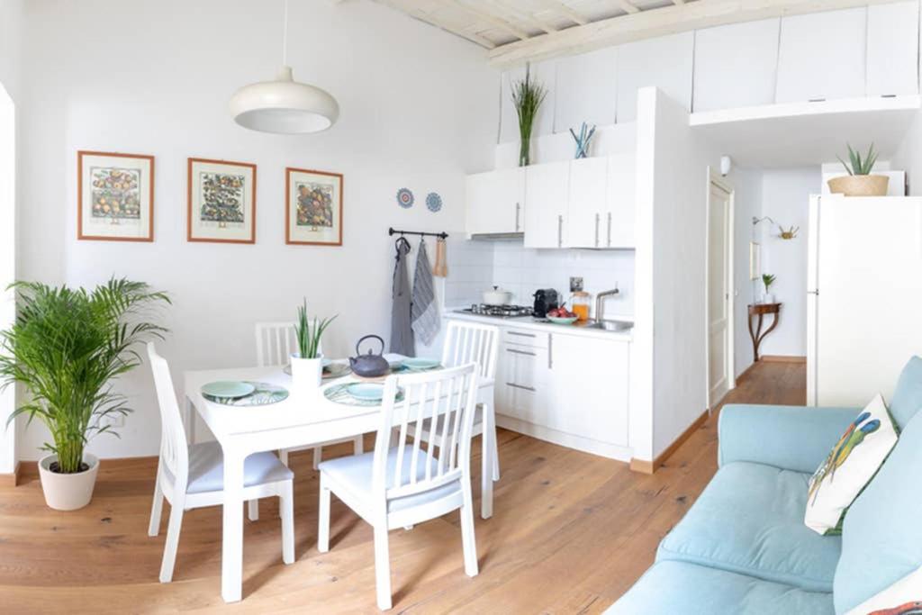 Il comprend une cuisine et une salle à manger avec une table et des chaises blanches. dans l'établissement Il Civettino - appartamento nel centro di Firenze, à Florence